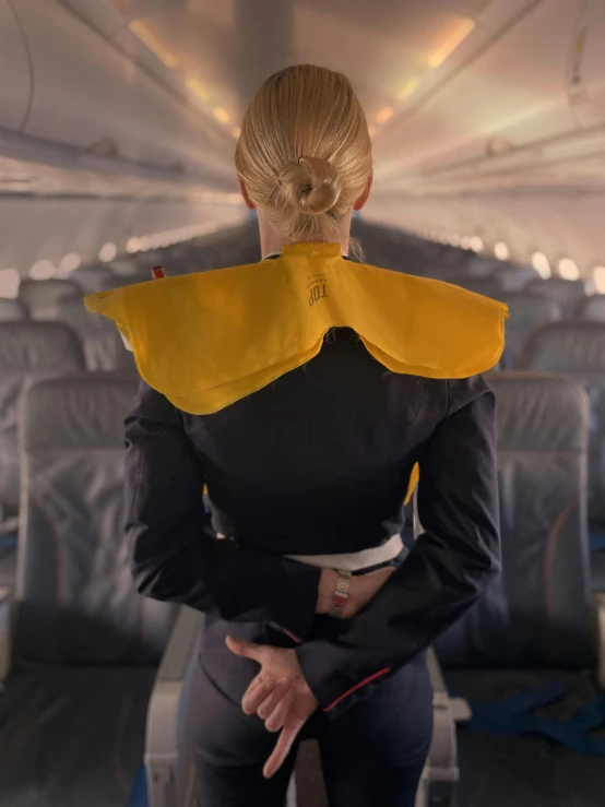 a woman on an airplane in the seat and some yellow wings