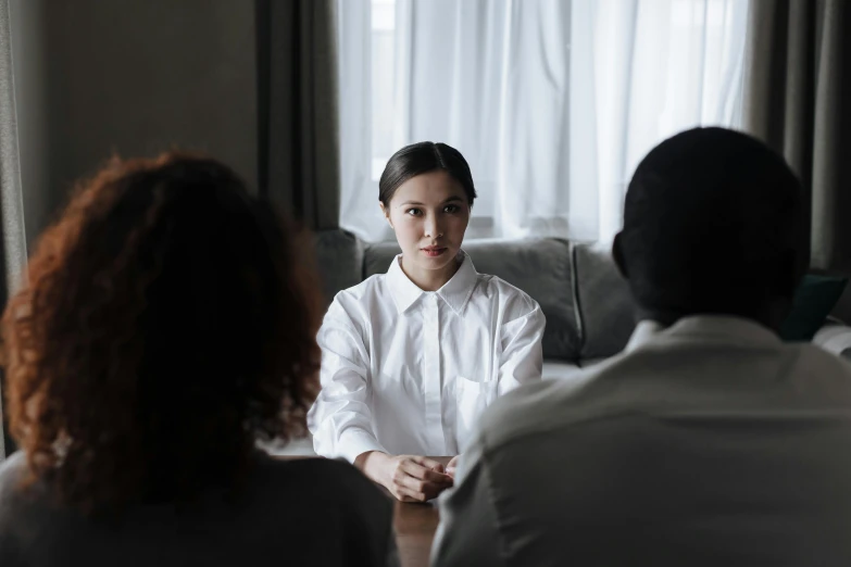 a lady is sitting and speaking with other people