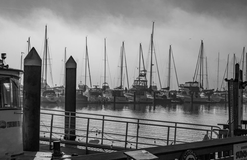 boats are docked in the harbor on a hazy day