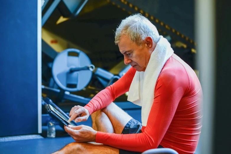 an older man sitting on the floor using his ipad