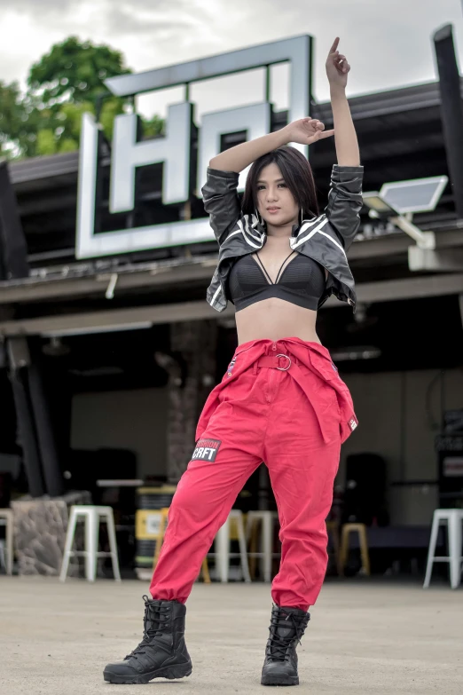 an asian woman in red and black pants dancing