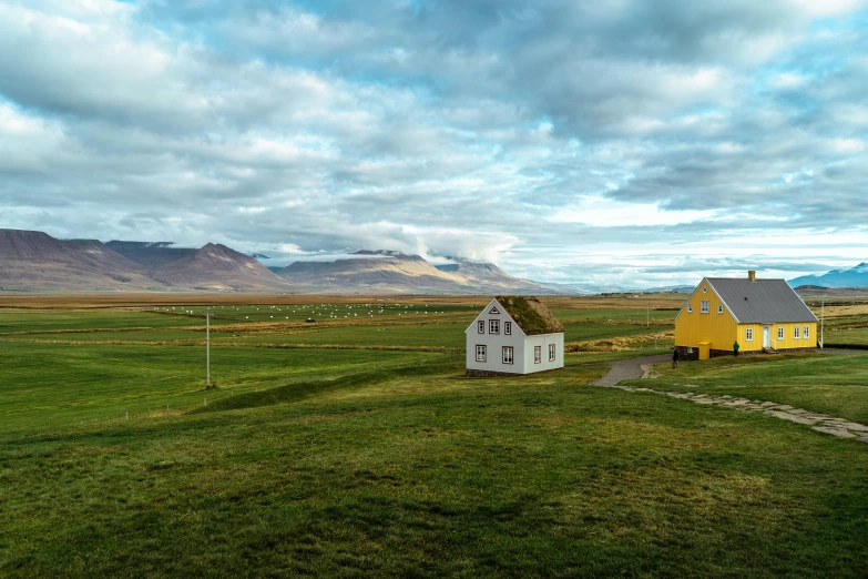 there is a yellow house that is in a large field