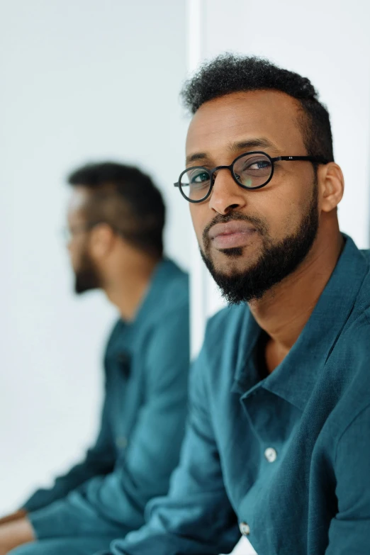 a man with glasses posing in front of another man