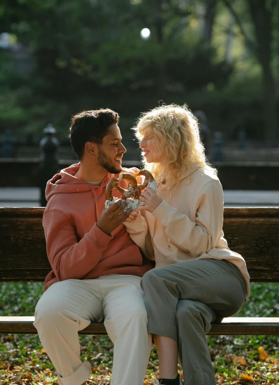 two people on a bench drinking beverages together