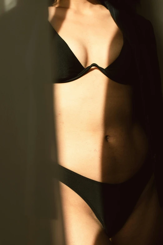 a woman with a  torso in a black bikini