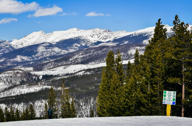 the mountains surrounding a ski resort are covered with snow