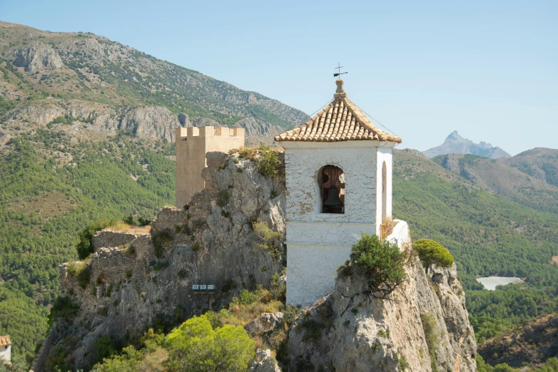 the bell tower is perched on the rock above the village