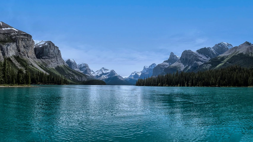 mountain range near a lake with blue water