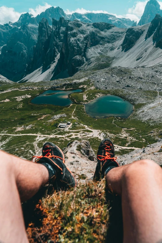 someone wearing hiking shoes is sitting on a mountain