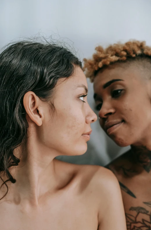 two women staring at each other, one has a small tattoo on her body