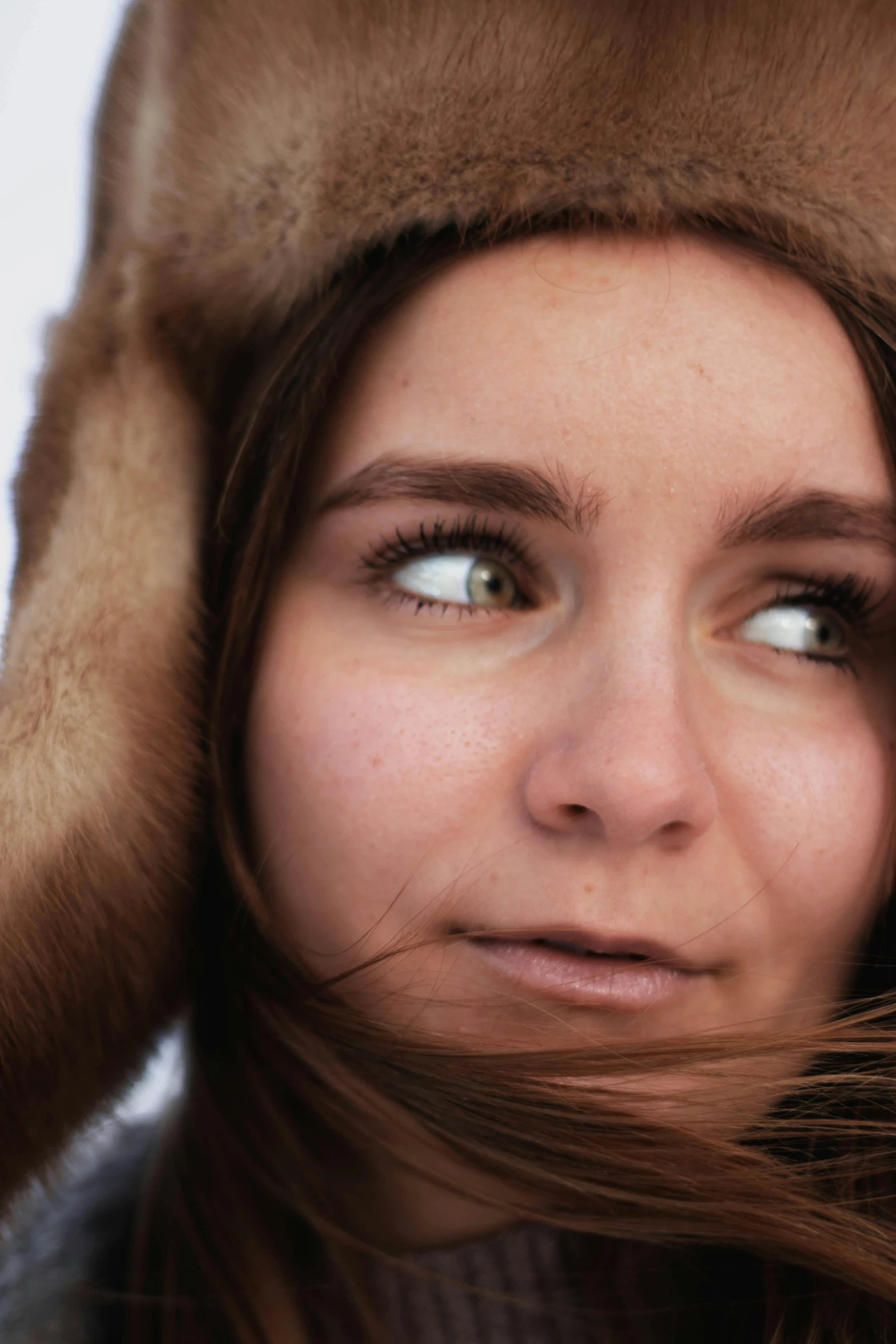 a woman with a hat is looking off into the distance