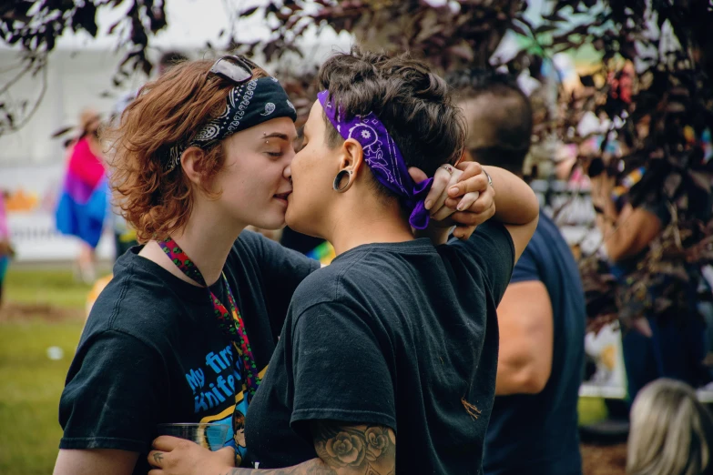 a couple kisses each other in a field
