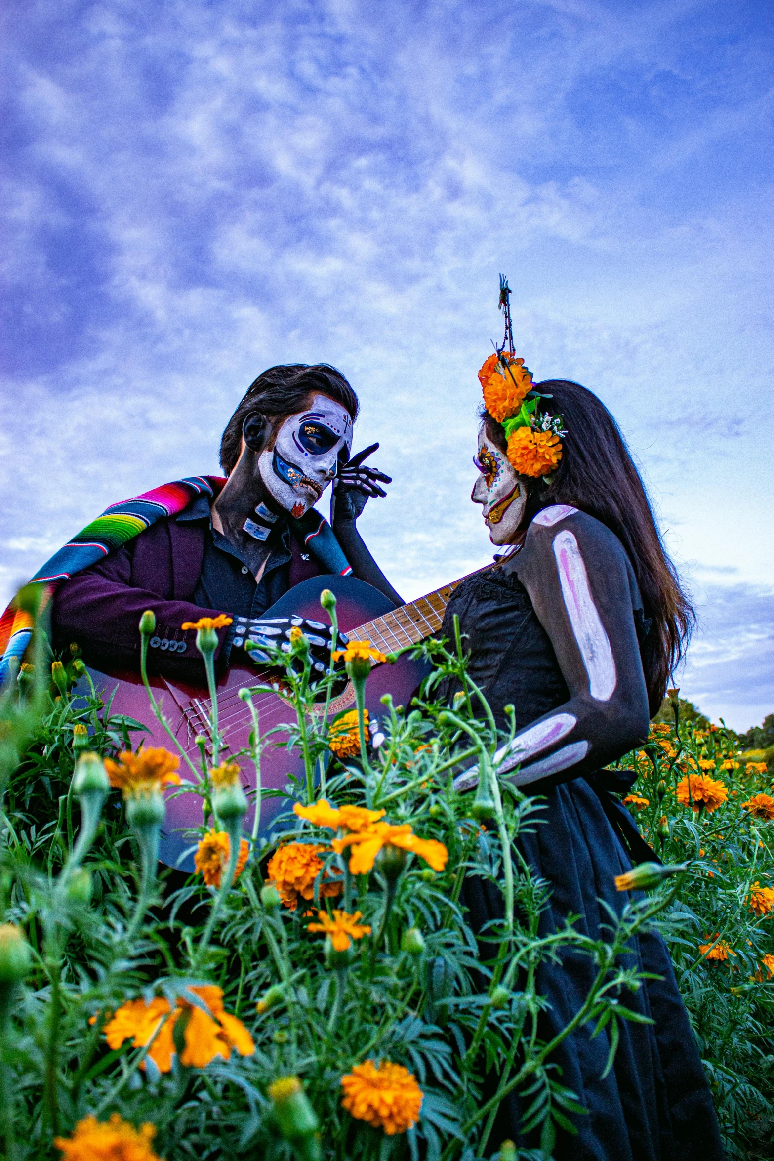 two people in makeup are playing guitar together