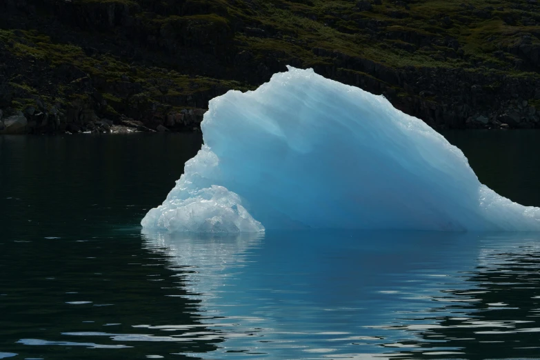 a melting large iceberg is sitting in the water