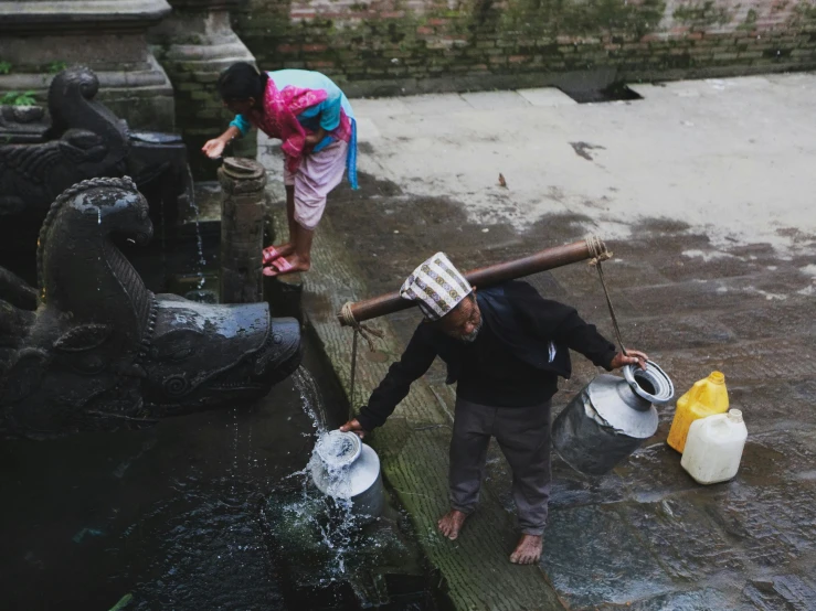 two children with bowls that are in the water