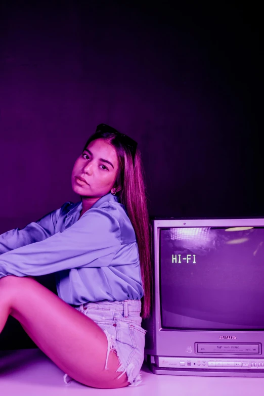 a female sitting by an old fashioned television