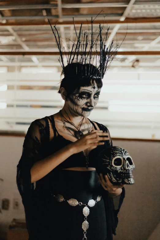 a person wearing makeup and holding a skull