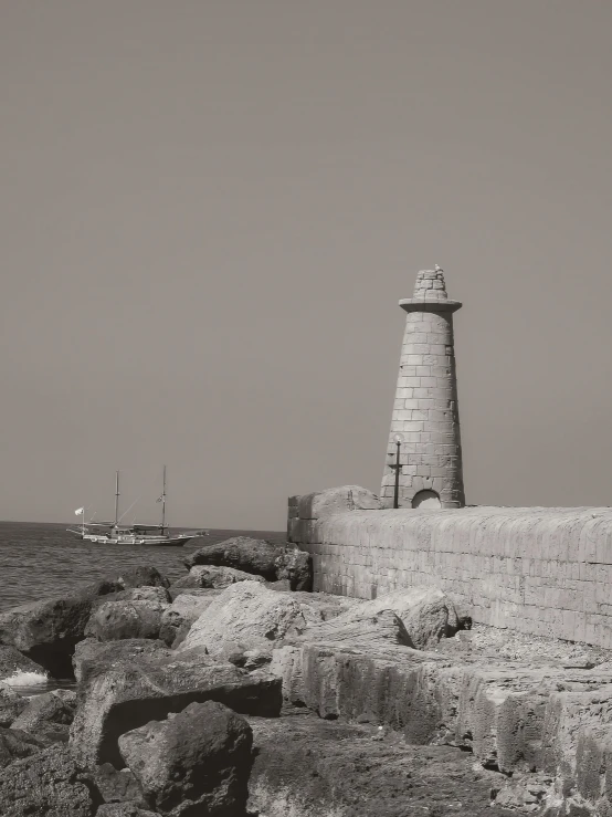 there is a lighthouse on the rocks near the water