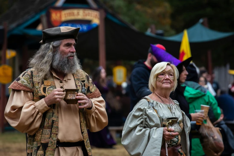 a man with a long beard and white haired woman standing next to each other