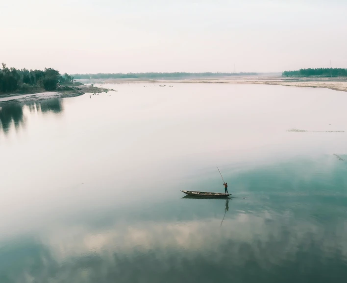 a man in a small boat on a body of water