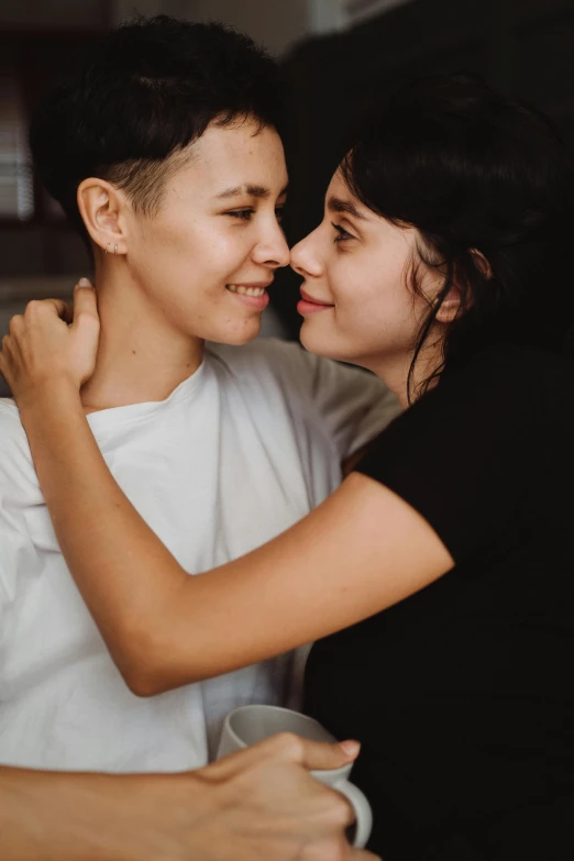 two people smiling while emcing each other and having some tea