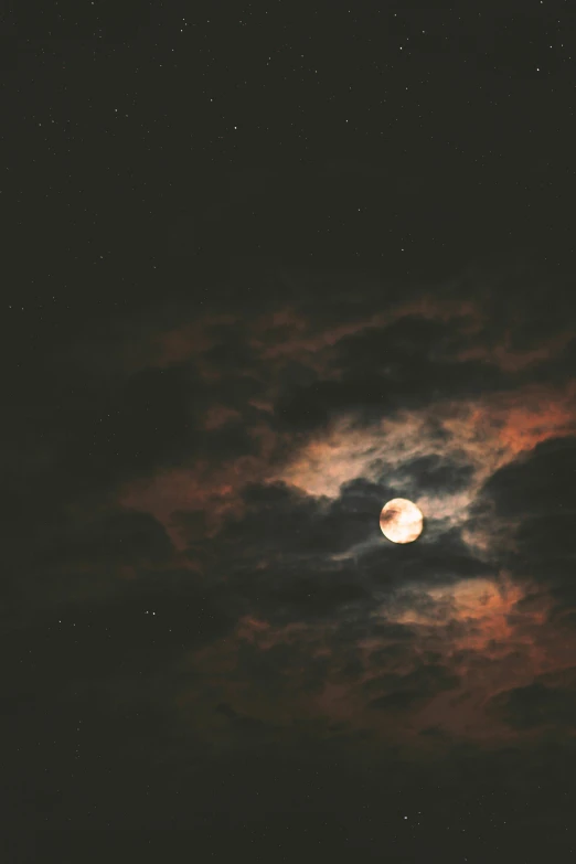 the moon is shining in the cloudy night sky