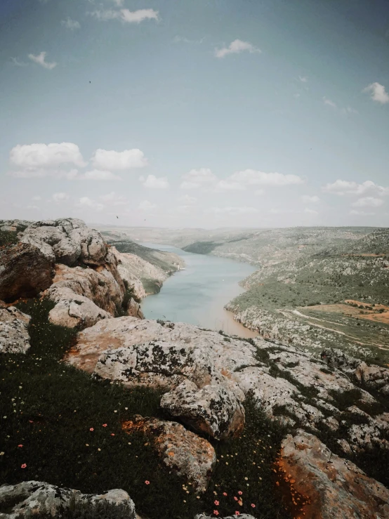 the lake is nestled next to rocks with vegetation and grass