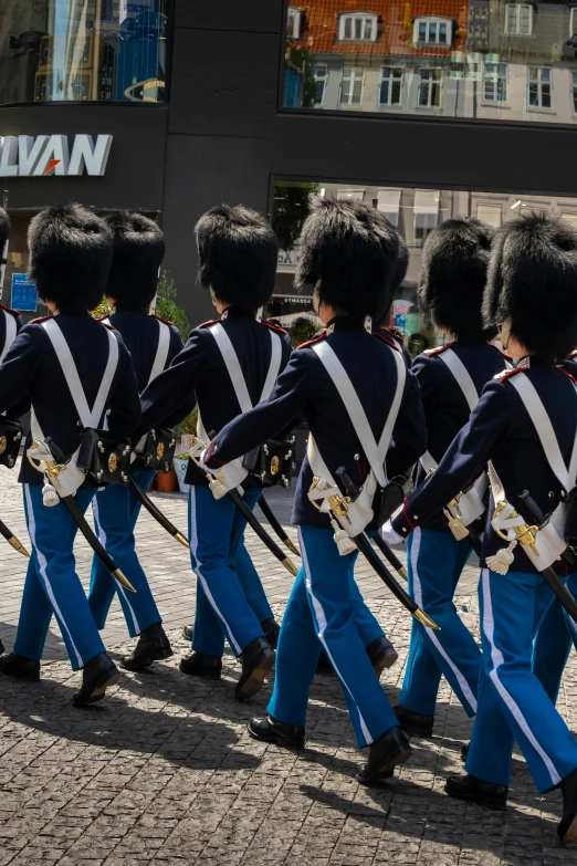 a group of people walking down a street with some kind of uniform