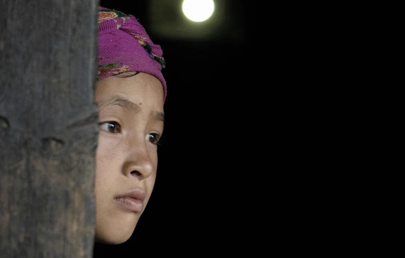 a  peeking her head out of a doorway