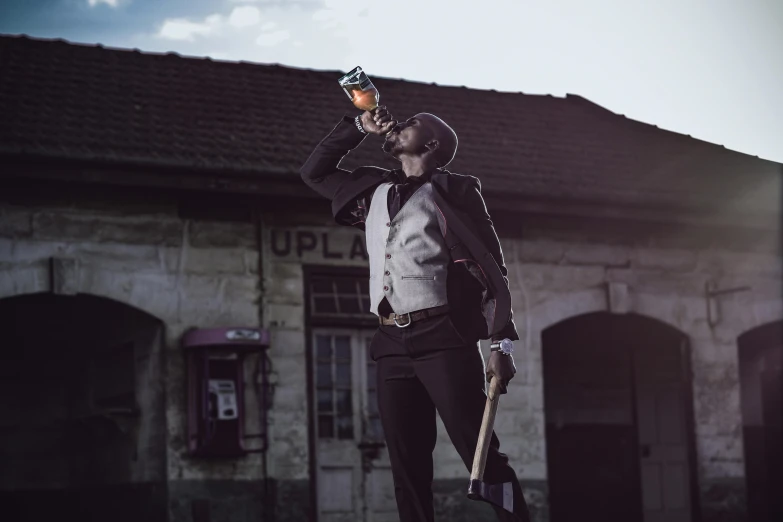 a man in a black hat and vest holding up a cell phone and a umbrella