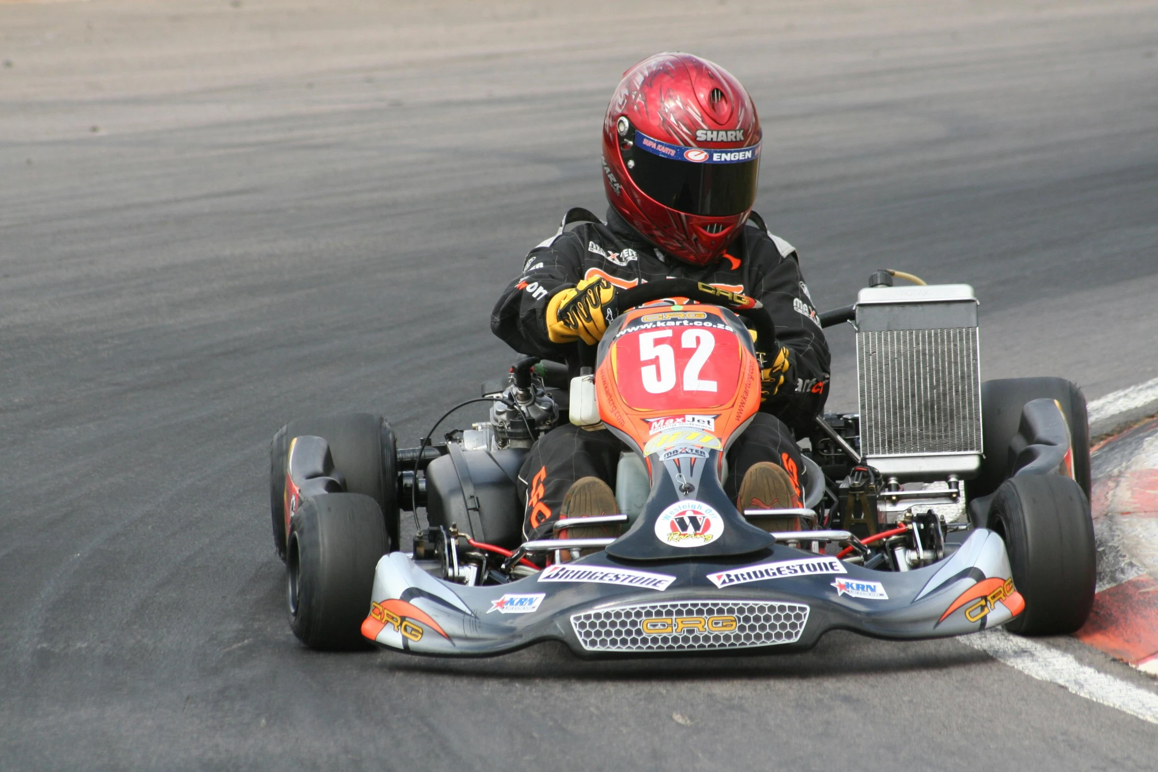 a person driving on a go kart, which is powered by a motor engine