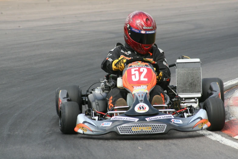 a person driving on a go kart, which is powered by a motor engine