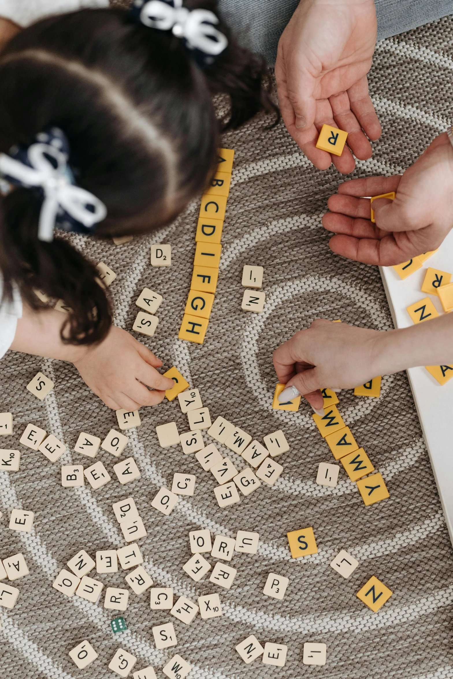 two s playing with wooden letters that spell out words