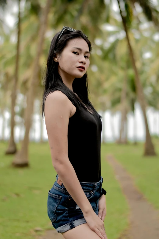 a beautiful young lady standing next to trees