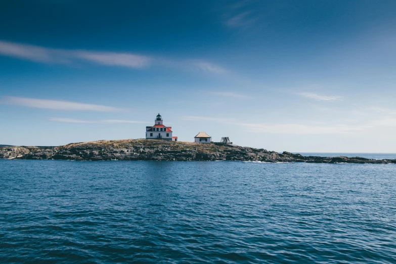 a white lighthouse in the middle of a body of water