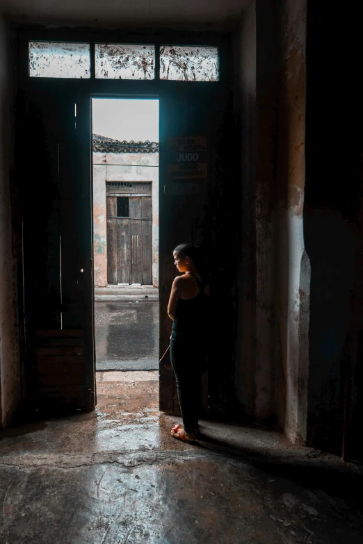 a person standing in the doorway of an empty building