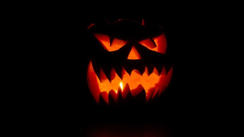 a carved pumpkin with glowing face lite up