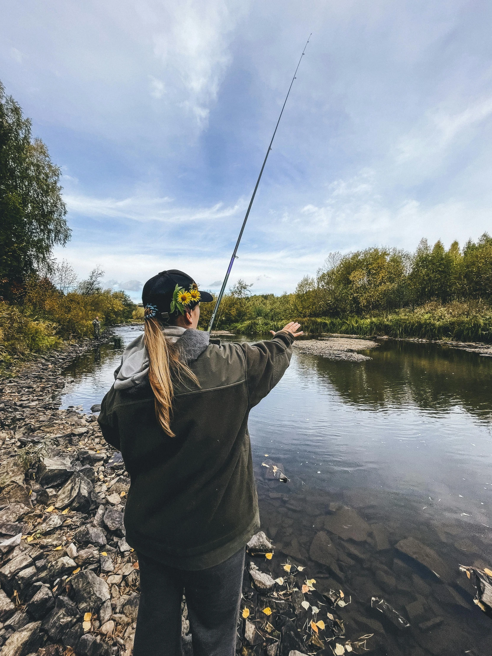 a man holding onto a fish next to a river