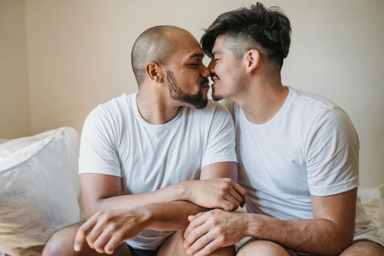 two young men are kissing each other on the bed