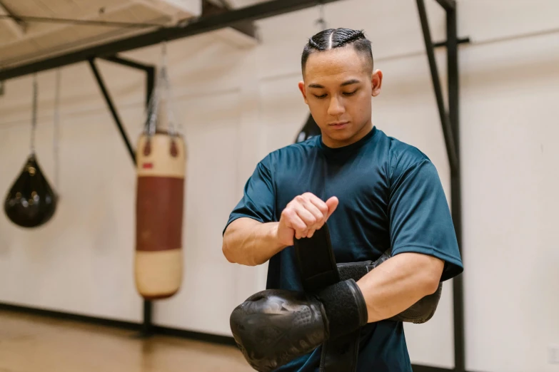 a man standing next to a boxing bag and punching