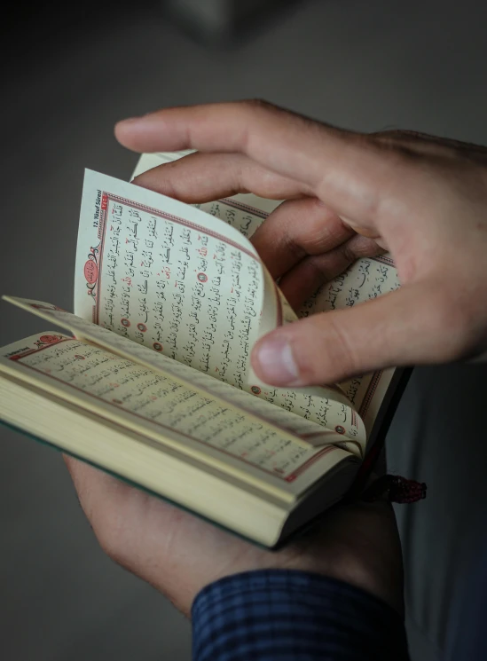 a person holding an open book in their hand