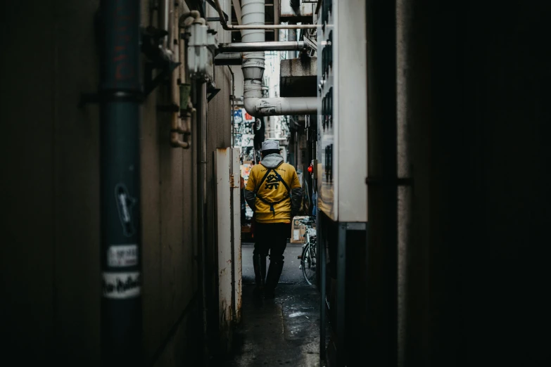 a guy walking down a long narrow alley way