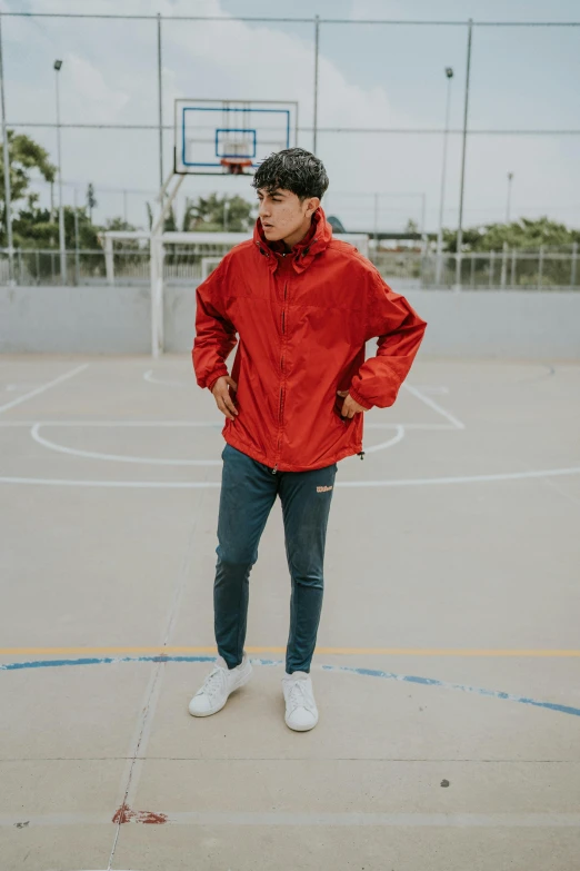 a man with his hands on his hips is standing on a basketball court