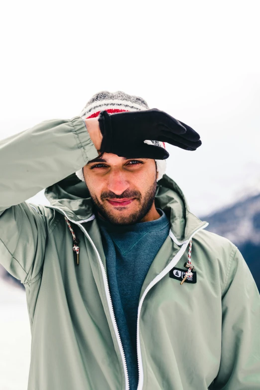 a man standing on the snow with a winter hat on