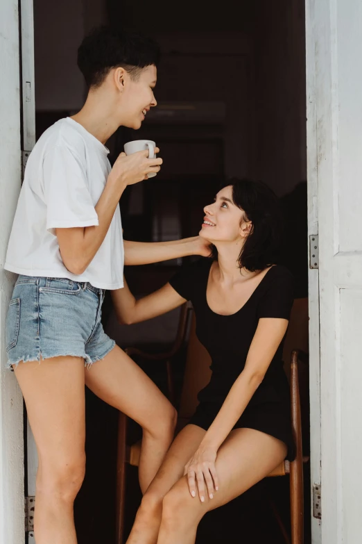 a boy and woman standing together, one holding coffee