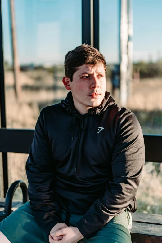 a young man sitting on top of a bench