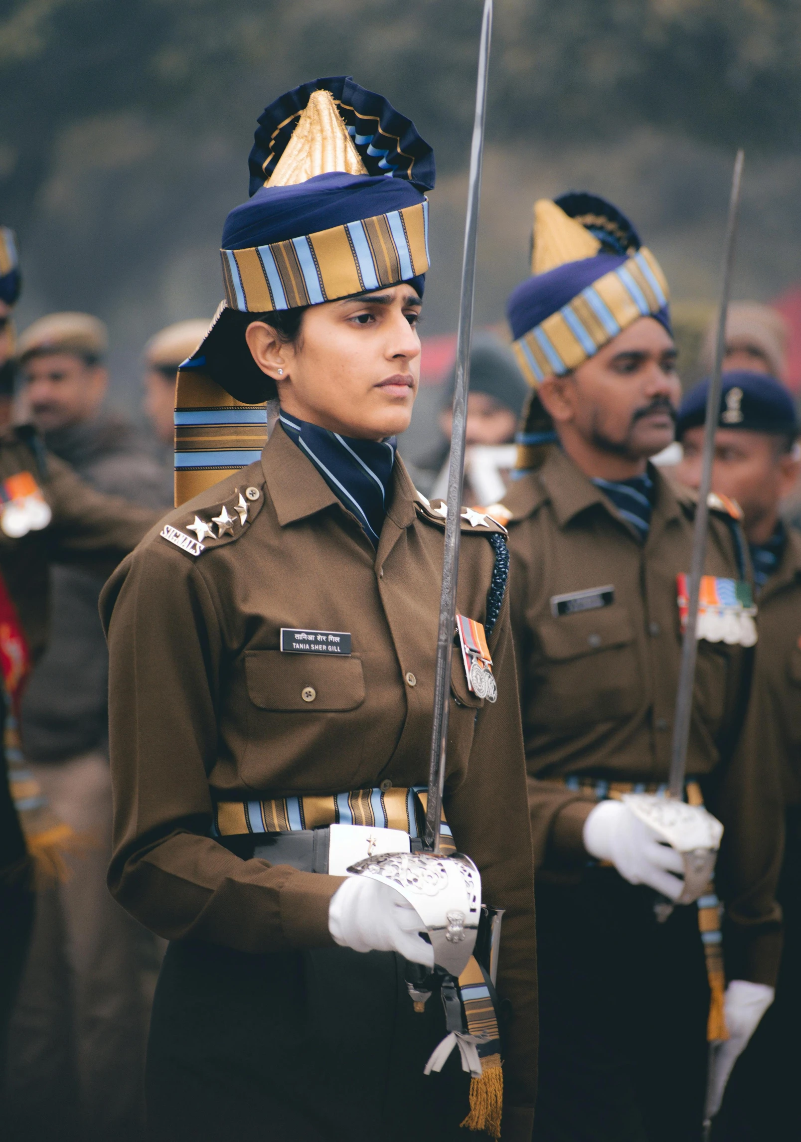 men in uniform are lined up holding poles