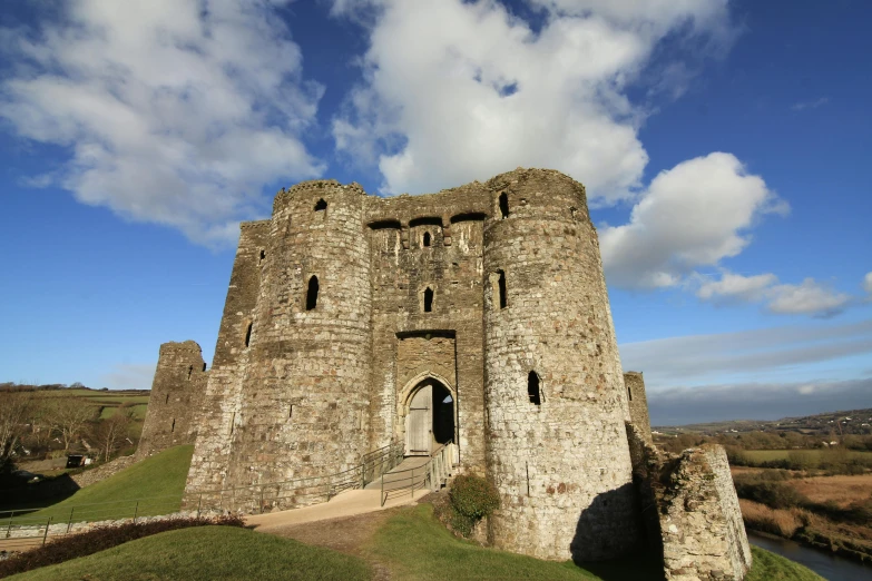 a very large castle building on a grassy hill