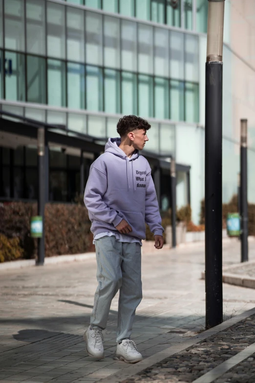 a man walking down the sidewalk near a street light