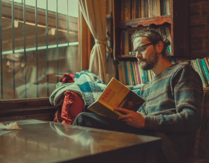 a man sitting down with a book in his hands